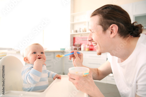 Father feeding his baby son