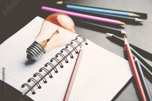 notebook with bulb and pencils