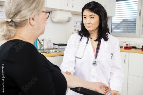 Confident Doctor Touching Senior Patient's Arm Before Blood Test