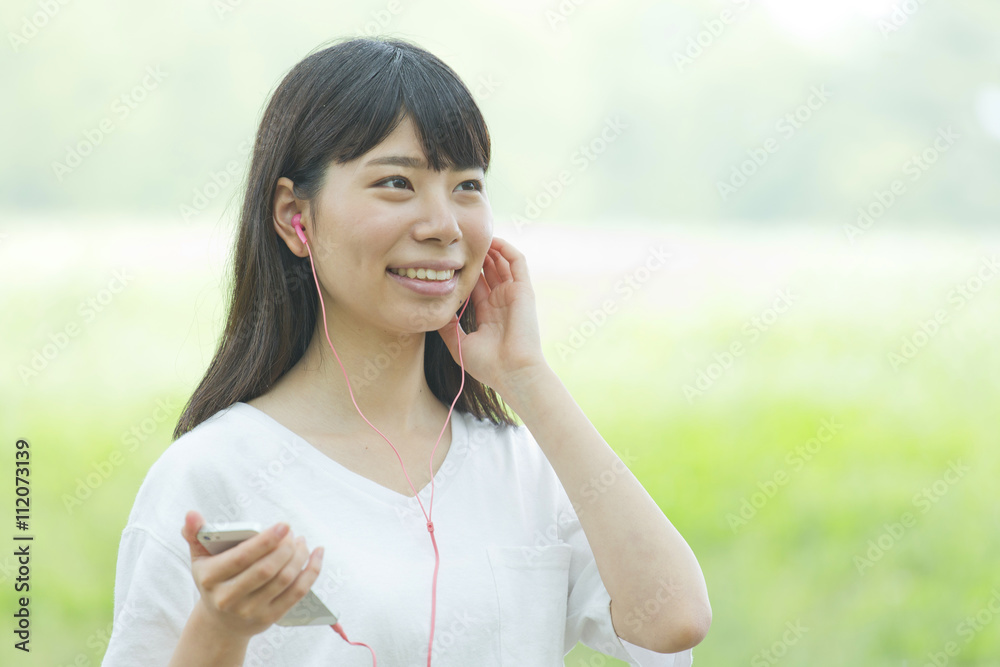 スマートフォンで音楽を聞く女性