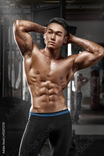 Sexy asian muscular man posing in gym, shaped abdominal. Strong male naked torso abs, working out