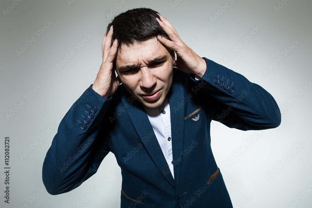 Young businessman holding a jacket with both hands on head Young businessman holding a jacket with both hands on head