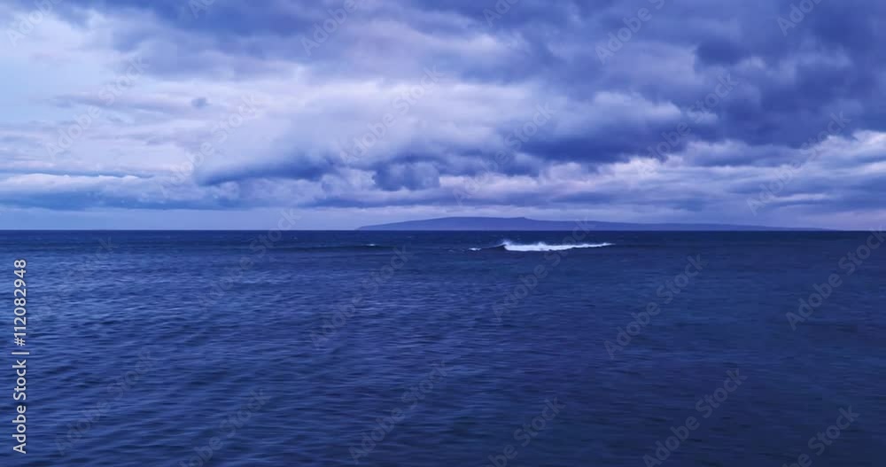Flying over ocean at dusk, aerial view flying over water with dramatic clouds Flying over ocean at dusk, aerial view flying over water with dramatic clouds