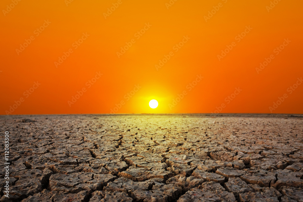 Golden sunset at a desert. Dry and thirsty soil.