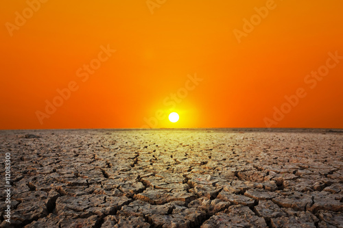 Golden sunset at a desert. Dry and thirsty soil.