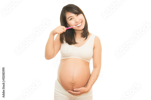 Pregnant woman brushing her teeth