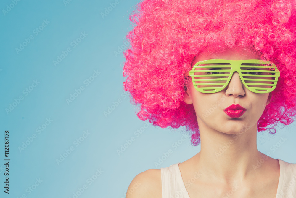 Portrait of beautiful woman in pink wig and green glasses