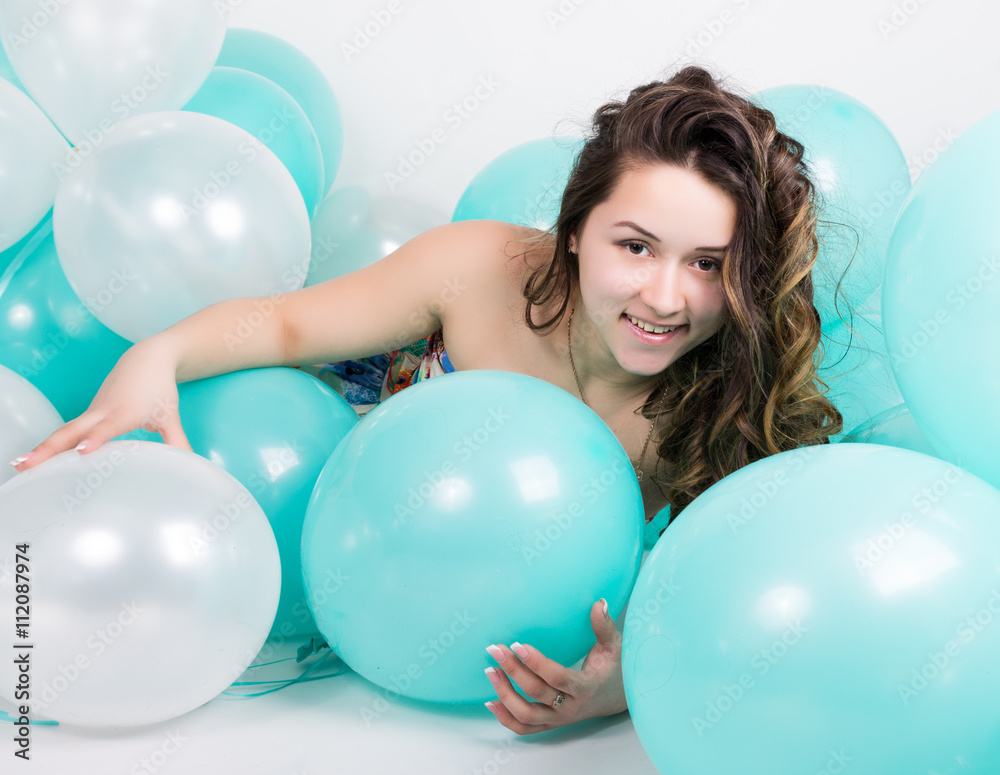 beautiful curly girl in a multi-colored dress playing with balloons beautiful curly girl in a multi-colored dress playing with balloons