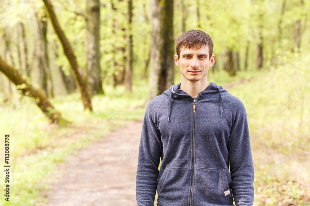 Young sportsman standing on trail after jogging Young sportsman standing on trail after jogging
