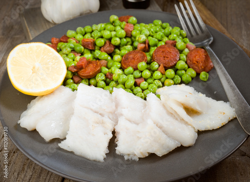 plate of grilled fish and cooked with ham and chorizo peas in ol photo