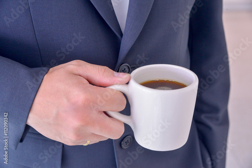 Close up businessman holding a cup of coffee.