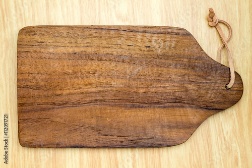 Foto Top view of dark brown wooden chopping block on light wood count