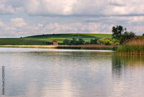 Peaceful lake landscape in the village under blue sky