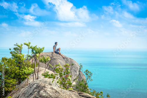 One man sits on a hill with stunning sea views © olezzo