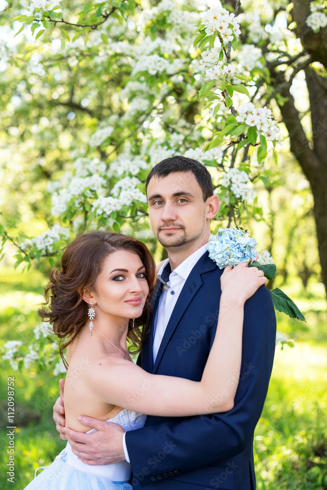 Young couple embracing in blooming spring garden. Love and romantic theme. Young couple embracing in blooming spring garden. Love and romantic theme.