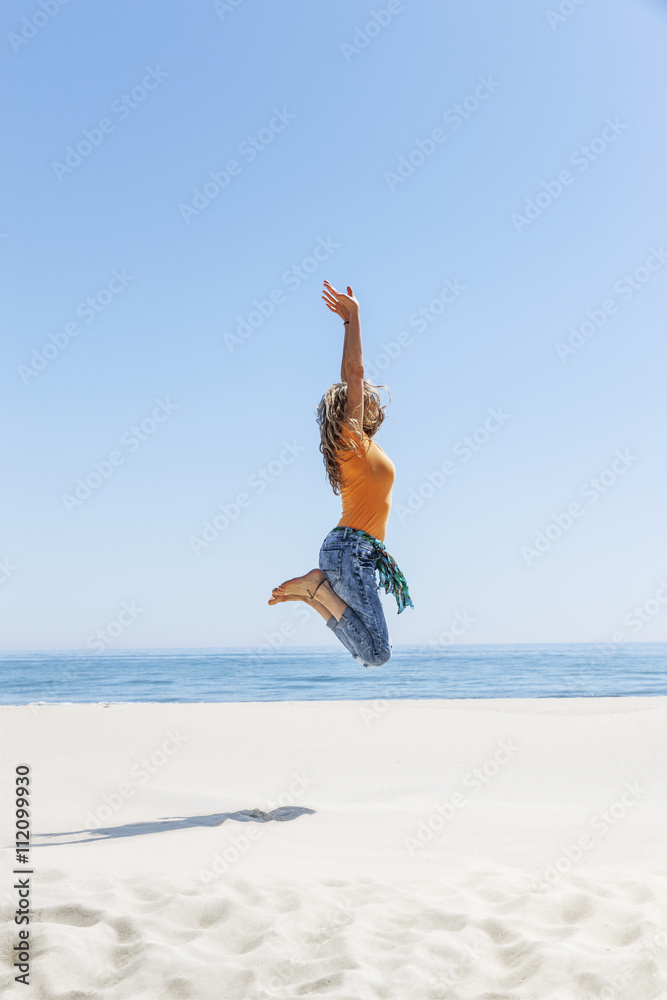 Frau hüpft am Strand