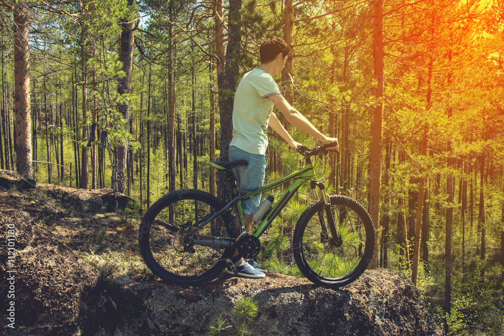 biker with bike on the rocks. Sport, adventure, motivation.