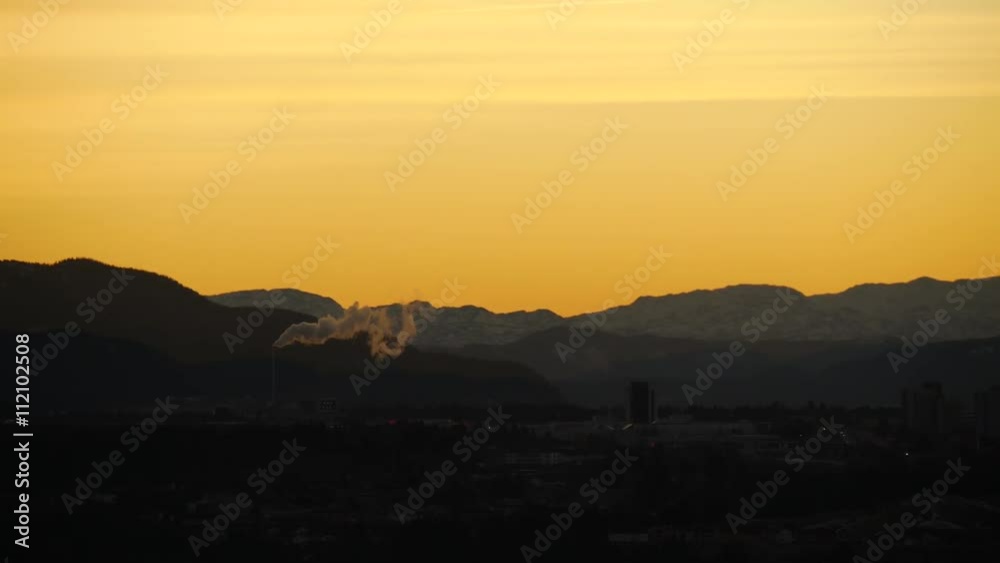 Magic hour sunset lights in northern mountains with smoking pipes, Norway Magic hour sunset lights in northern mountains with smoking pipes, Norway
