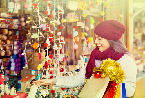 Happy young woman choosing Christmas decoration