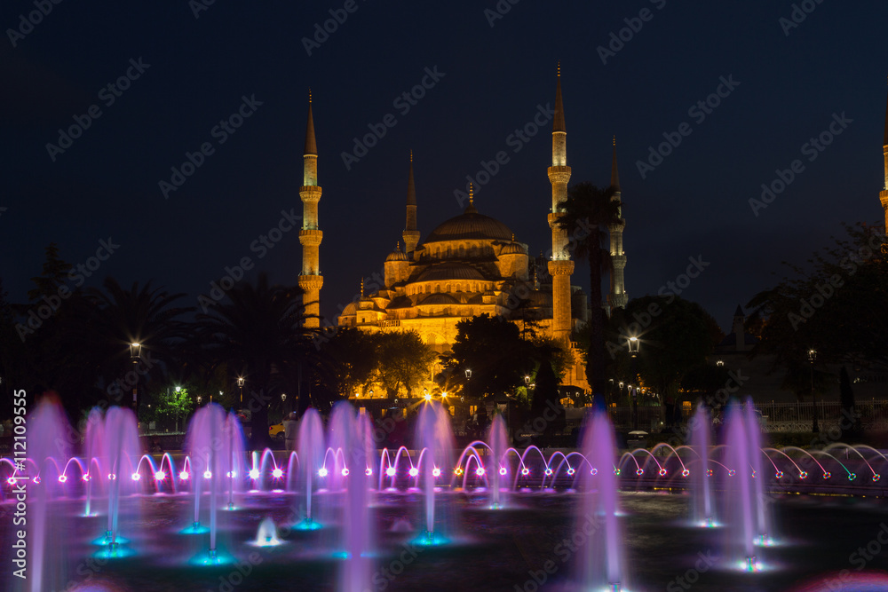 fountain with blue illumination on Sultanahmet square in front of the Blue mosque (Sultan Ahmed Mosque)in Istanbul in the evening