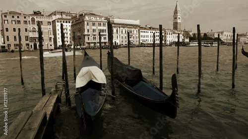 Gondolas rocking on the waves with Piazza San Marco on the background in Venecia, Italy photo