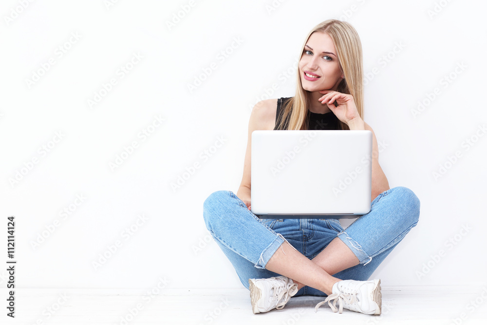 Happy young woman sitting on the floor and using laptop Happy young woman sitting on the floor and using laptop