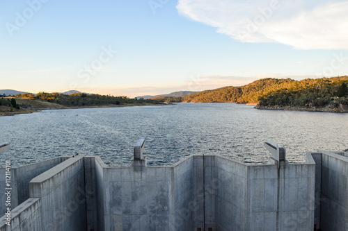 Weighted flood gates on Jindabyne Dam, Snowy River.  The surrounding mountain landscape and cloudscape.  Lake Jindabyne is part of the ground breaking 'Snowy Mountains Hydro-Electric Scheme'.