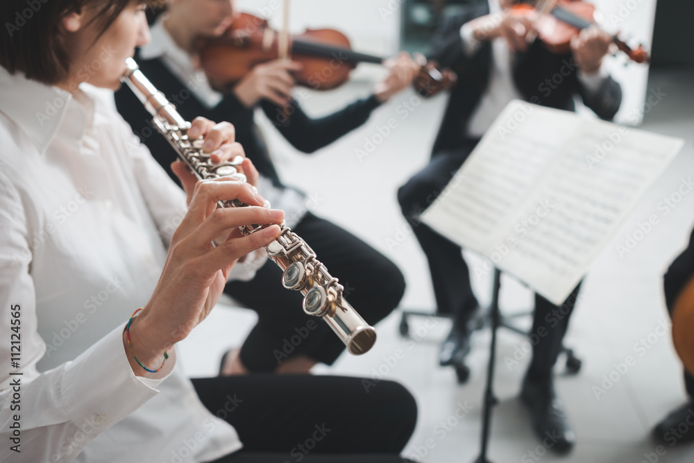 Fototapeta premium Flutist playing her instrument on stage