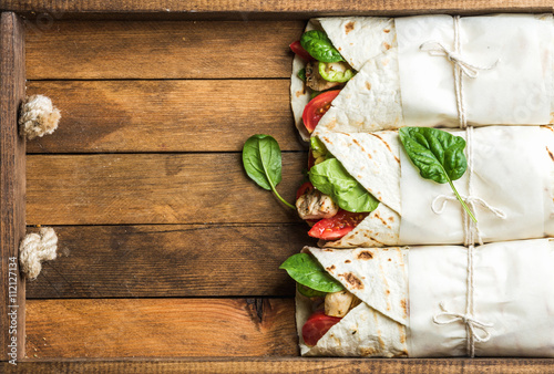 Healthy lunch snack. Tortilla wraps with grilled chicken fillet and fresh vegetables photo