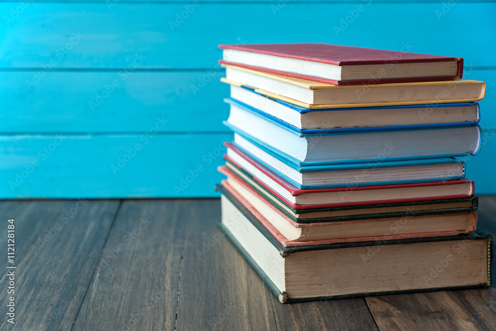 Fototapeta premium book stack with blue wooden wall background