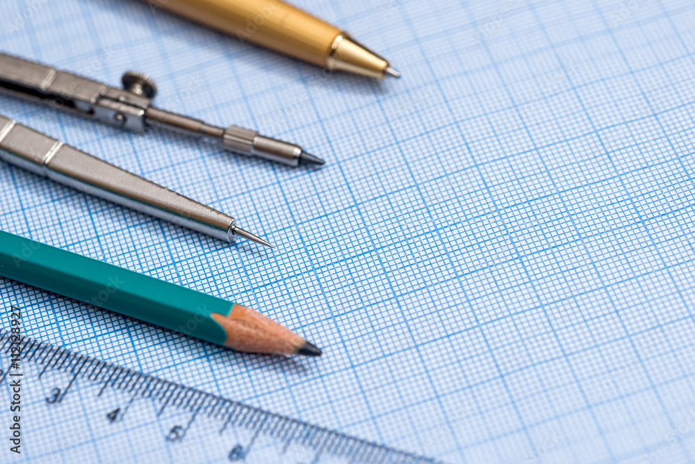 drawing compass, pencil, and ruler on graph paper background drawing compass, pencil, and ruler on graph paper background