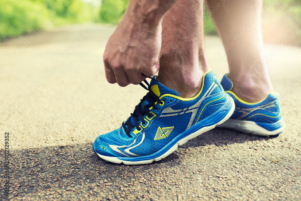 Runner tying his running shoes. Road forest man shoelace sneaker