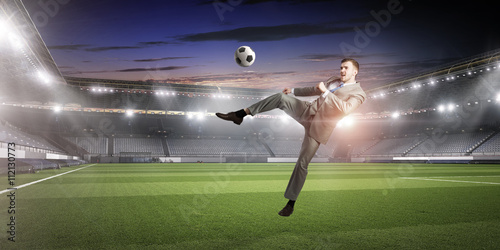 Businessman kicking ball © Sergey Nivens