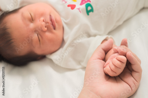 selective focus hand the sleeping baby in the hand of mother clo