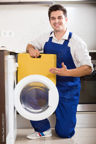 serviceman posing near washing machine