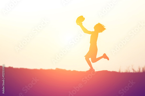 a silhouette of a happy young girl child  in hands give heart th