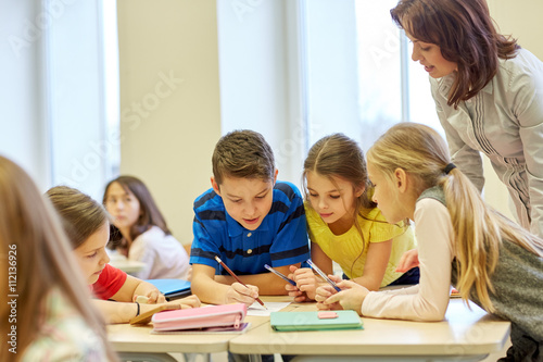 group of school kids writing test in classroom