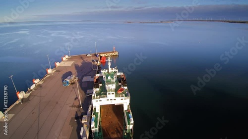 The big blue sea on the Virtsu harbor in Estonia where there is a big ferryboat and other sea vessels photo