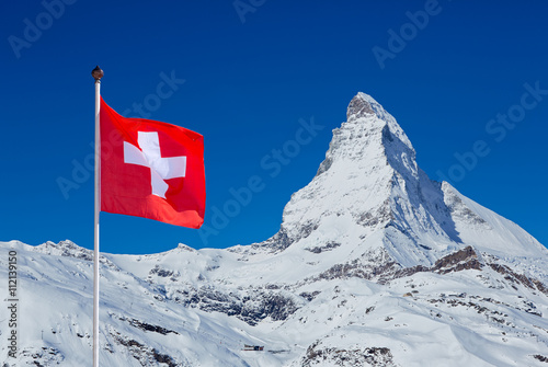 Famous Matterhorn with flag of switzerland on blue sky