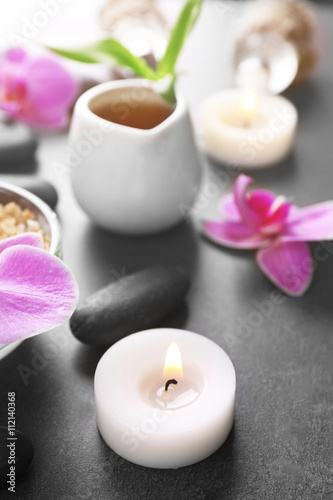 Beautiful spa set with candle and orchid on the table, close up