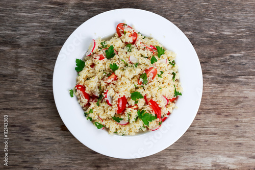 Homemade Fresh Couscous salad with vegetables, in white plate.