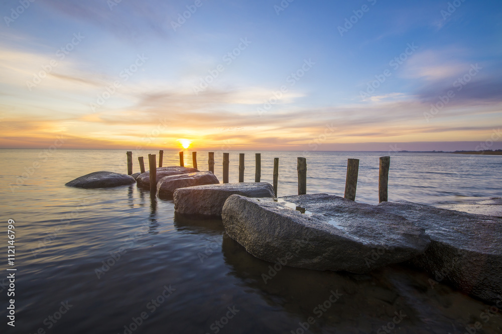 sea landscape, boulders in the water,sunset and colorful sky, slow shutter speed