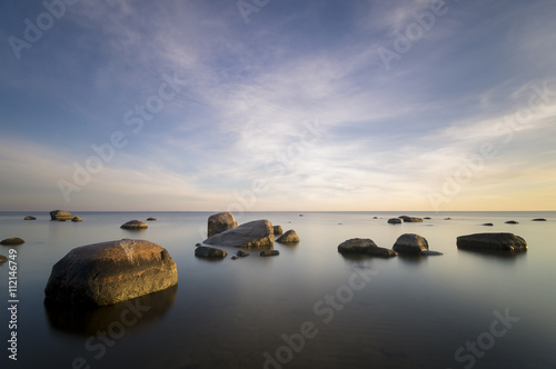 sea landscape, boulders in the water,sunset and colorful sky, slow shutter speed