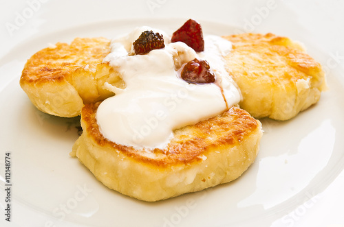 Cheesecakes with sour cream and jam on a plate © alexandrink1966