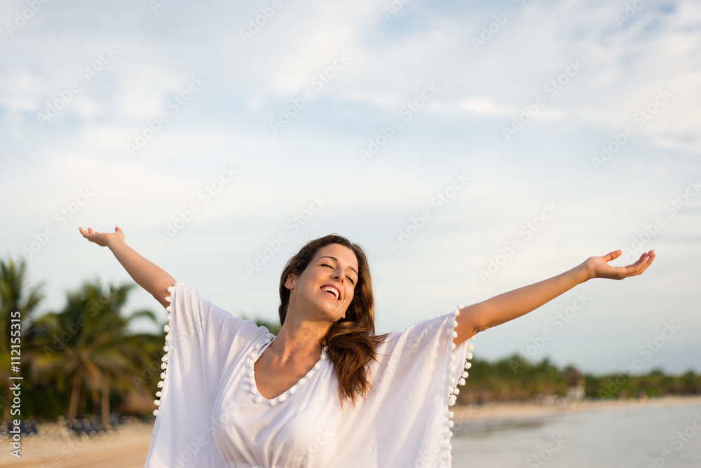 Blissful woman at tropical beach enjoying relax, freedom and vacation. Brunette female raising arms to the sky. Summer happiness and leisure. Blissful woman at tropical beach enjoying relax, freedom and vacation. Brunette female raising arms to the sky. Summer happiness and leisure.