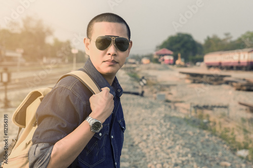 Young asian man traveler is waiting at the railway station © amnadbumrungvong