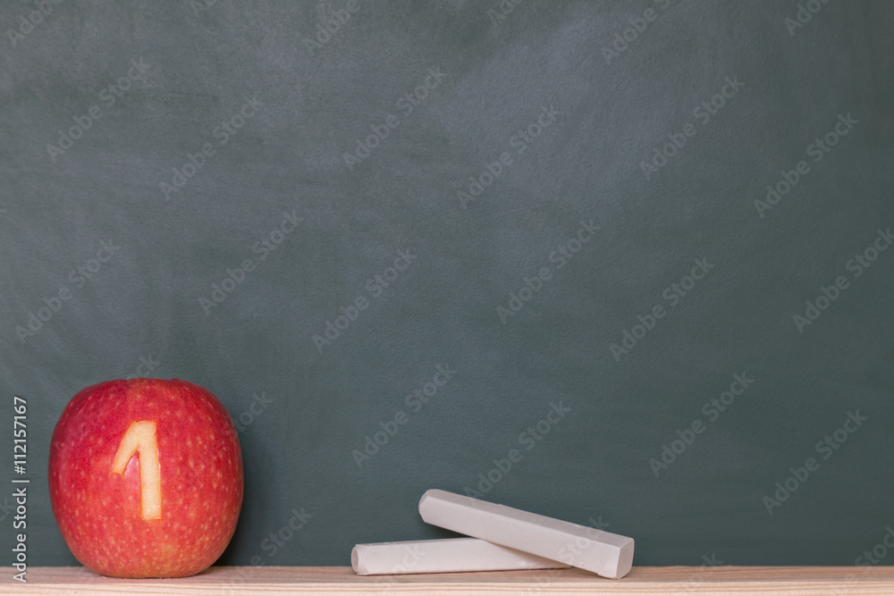 eine roter Apfel mit einer Zahl vor einer Tafel eine roter Apfel mit einer Zahl vor einer Tafel