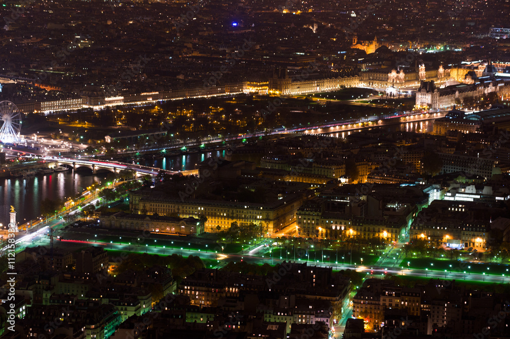 Aerial Night view of Paris City and Seine river shot on the top of Eiffel Tower