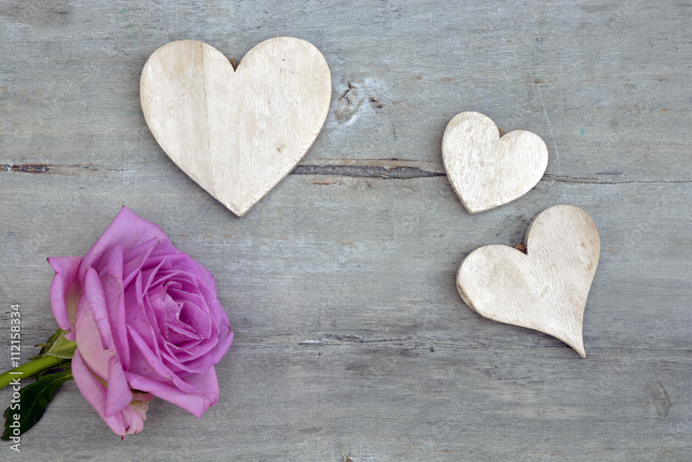 Fototapeta premium Pink purple rose on a grey old wooden background with white wash heart shape tags with empty copy space 