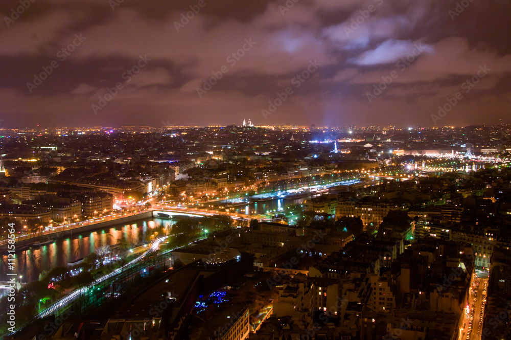 Aerial Night view of Paris City and Seine river shot on the top of Eiffel Tower